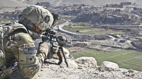 Soldier and Afghan Village. International Courts. U.S. Army. Staff Sgt. Ryan C. Matson